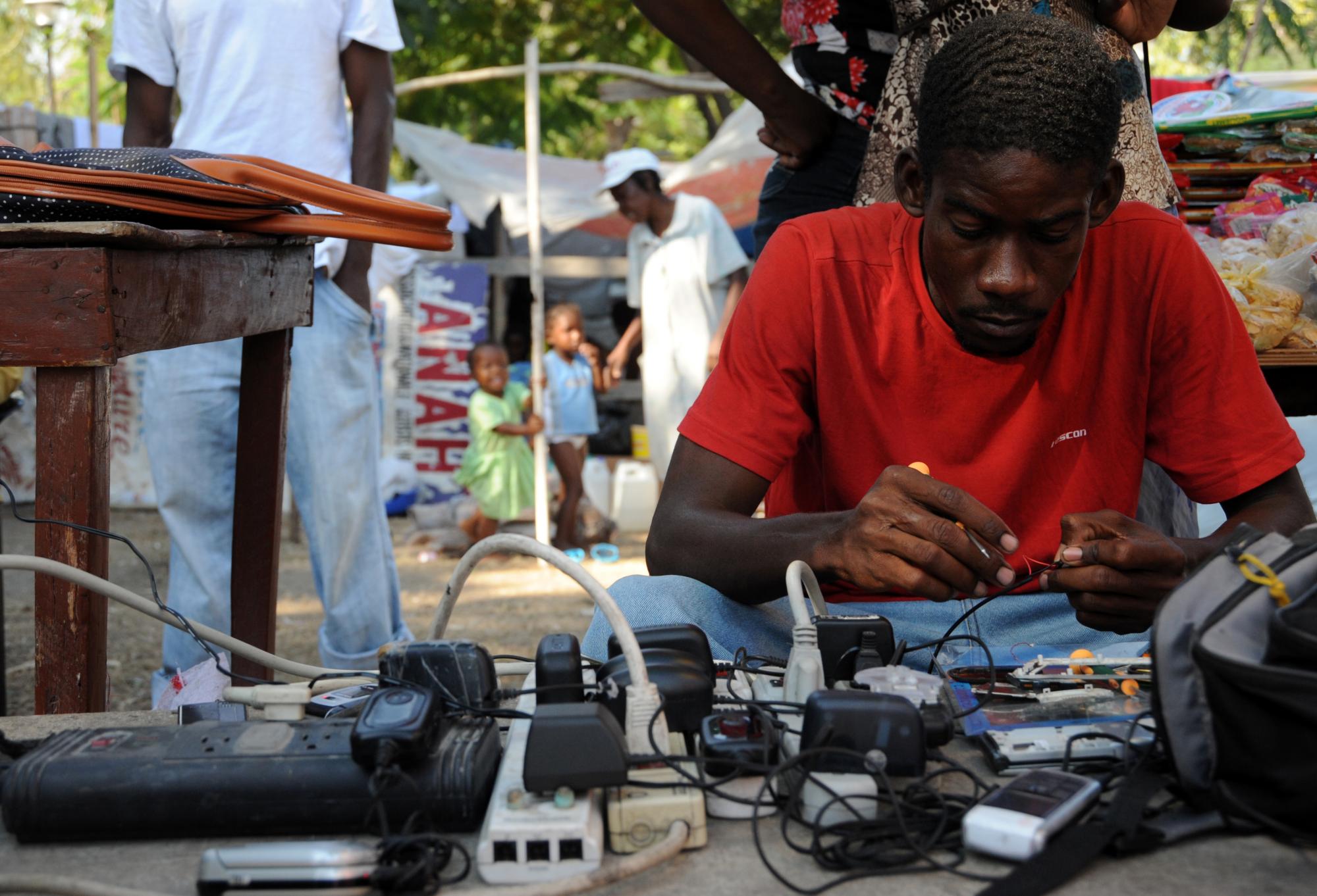 A man in Haiti fixes mobile phones.